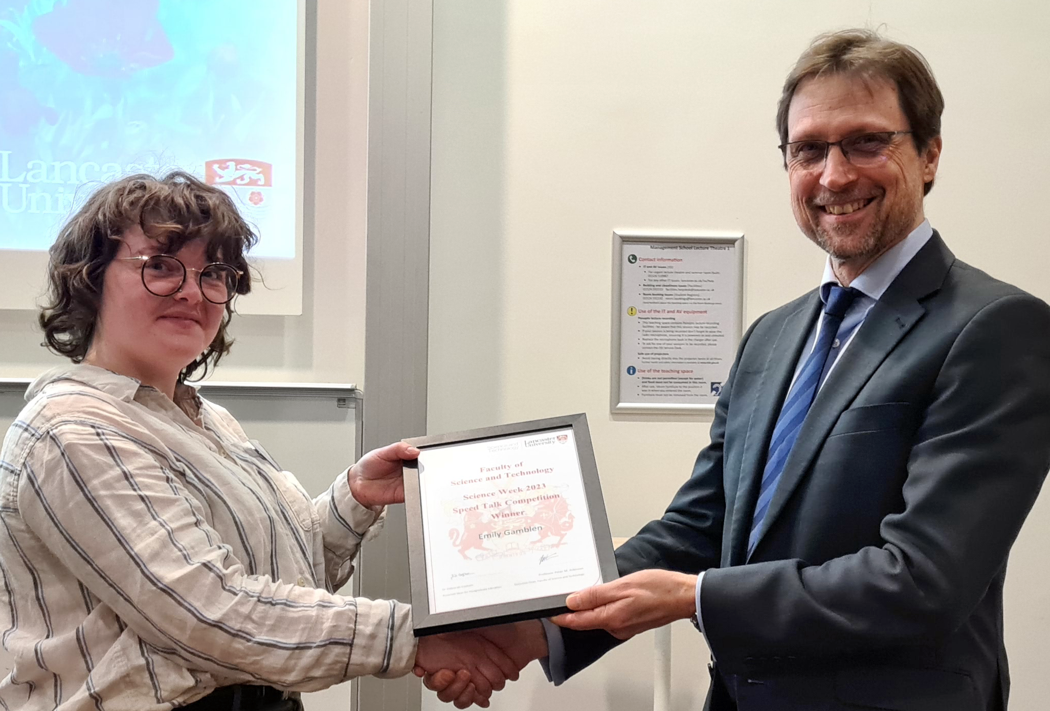 The Dean of the Faculty of Science and Technology presenting Emily with prize certificate